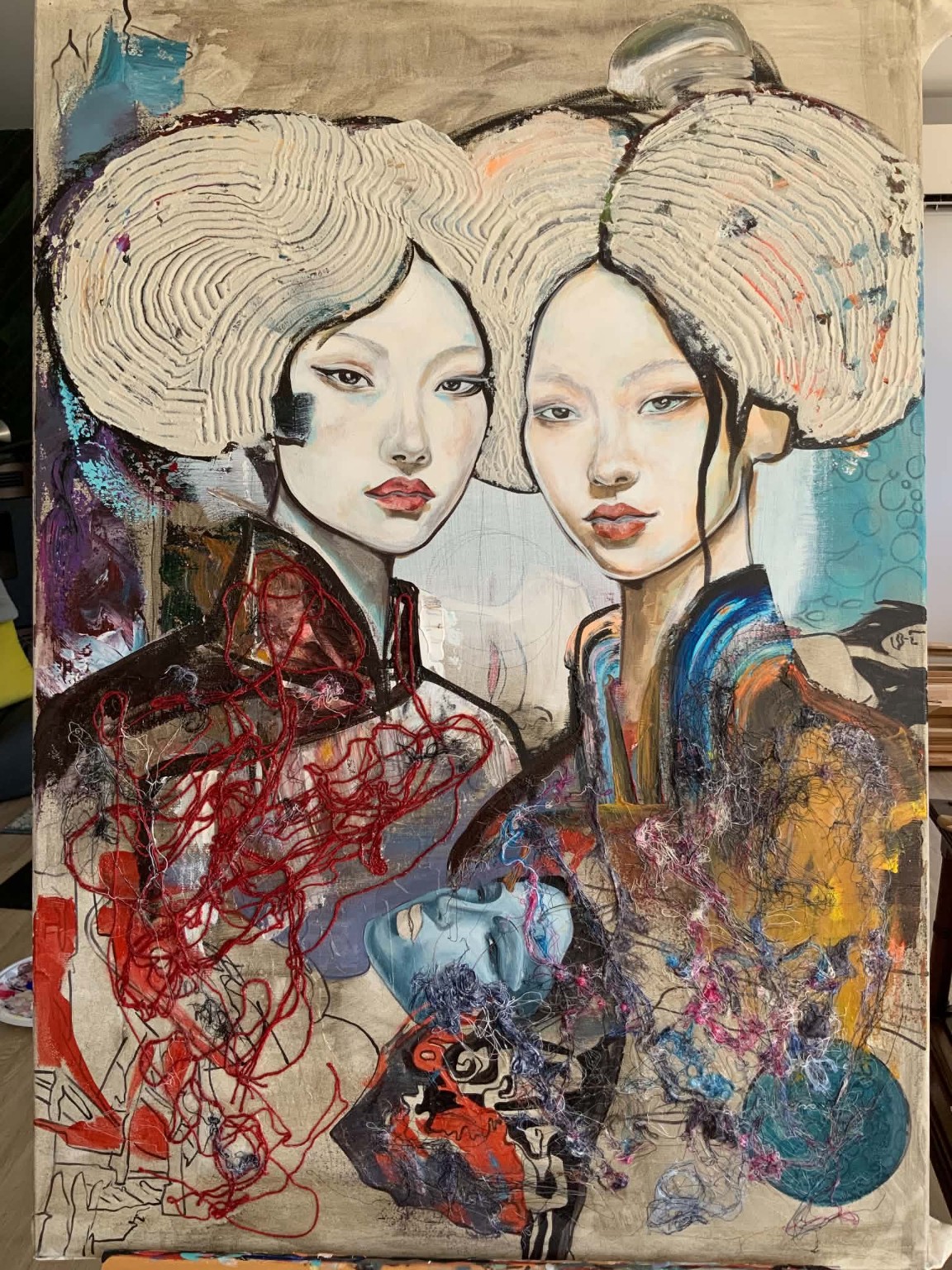 Two women with textured thread-like red and blue surfaces